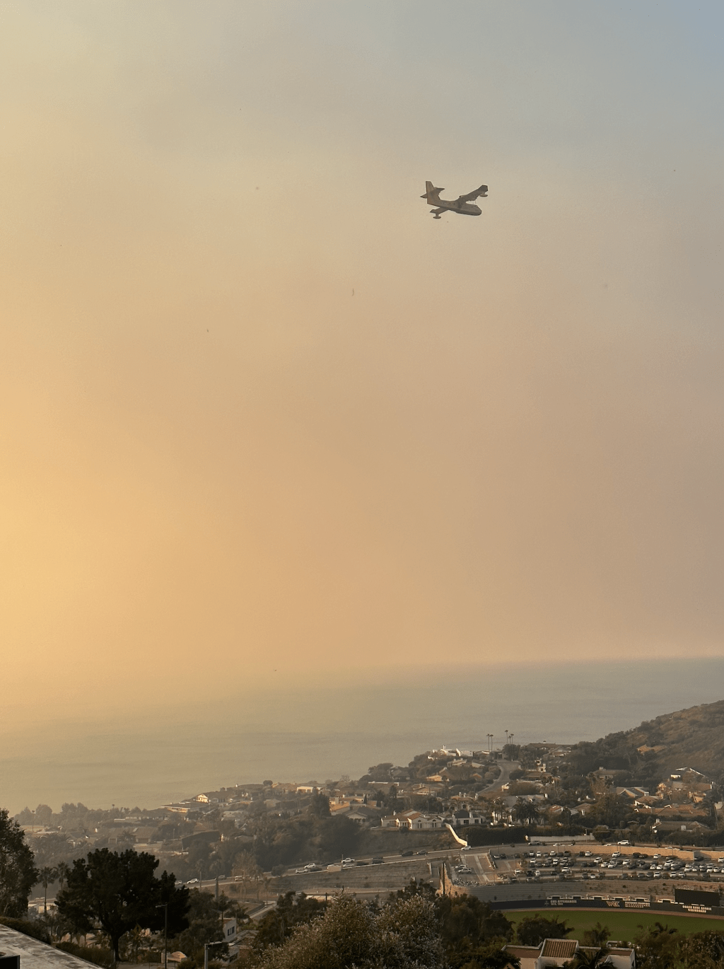 A plane flies over campus. Firefighting crews worked to extinguish the flames.